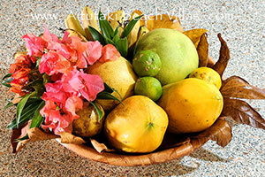 picture of fruit bowl with pawpaw, grapefruit and lemon decorated with pink boungainvillea
